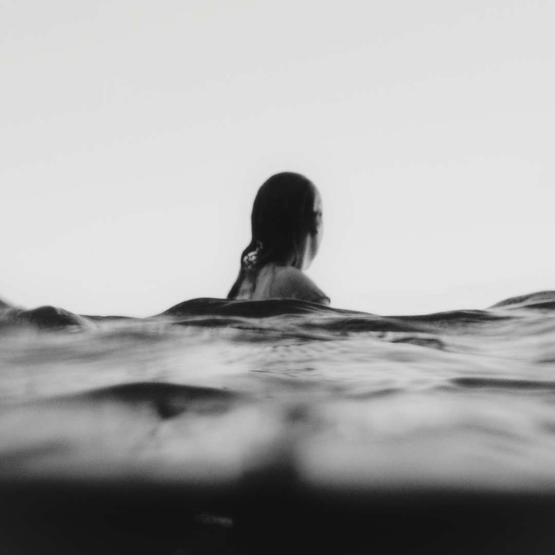 Calico Sky Studio - Behind The Scenes Woman swimming in the sea, black n white aesthetic beach vibes; founder story of calico sky studio webdesign & branding