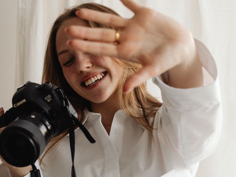 Blonde Frau mit Kamera bei der Vorbereitung zum Personal Branding Fotoshooting