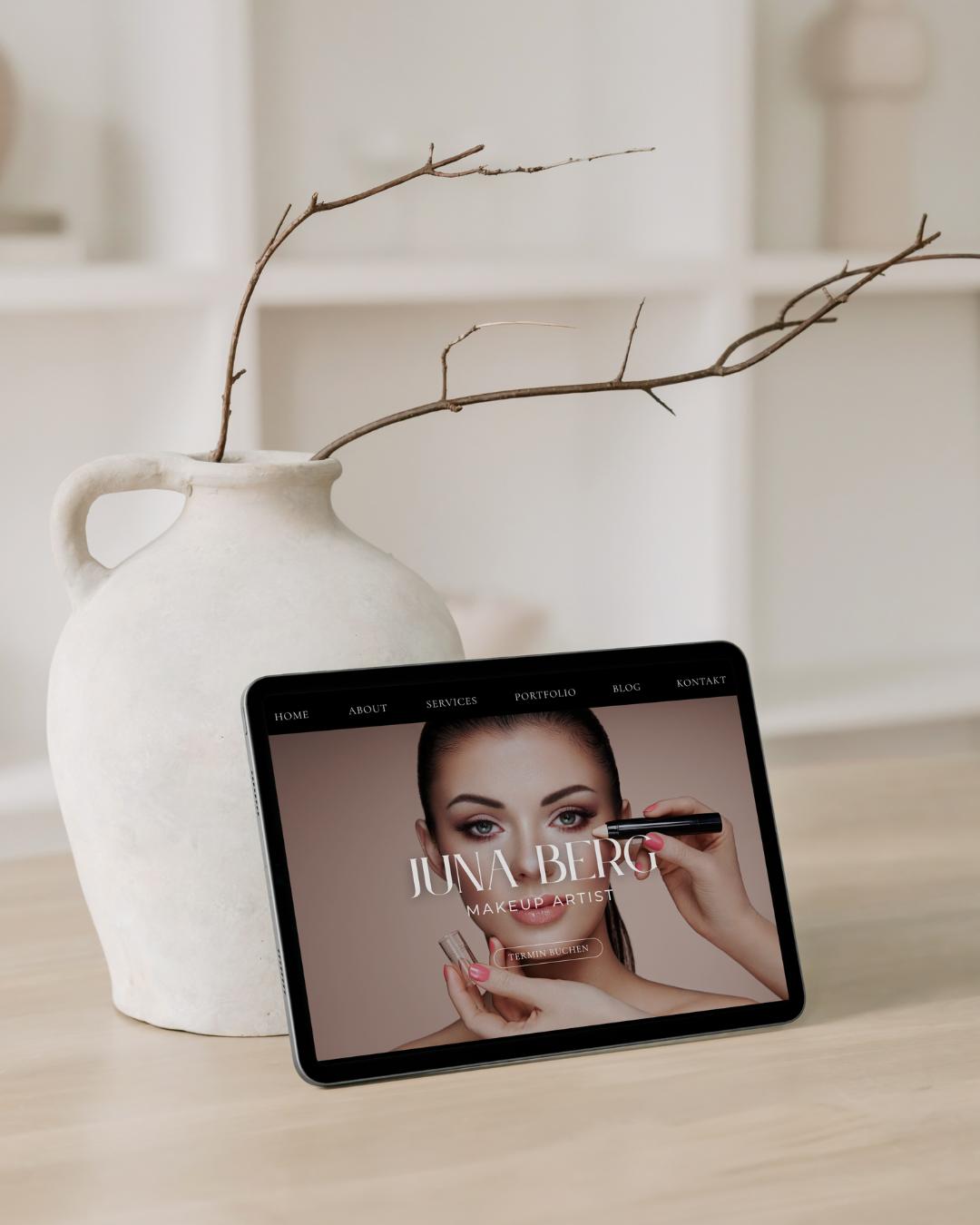 Calico Sky Studio - Premium Webdesign Weiße Designer Vase mit Dekozweig, davor steht ein Tablet mit der Website für Make-up Artist - Premium Webdesign von Calico Sky Studio.