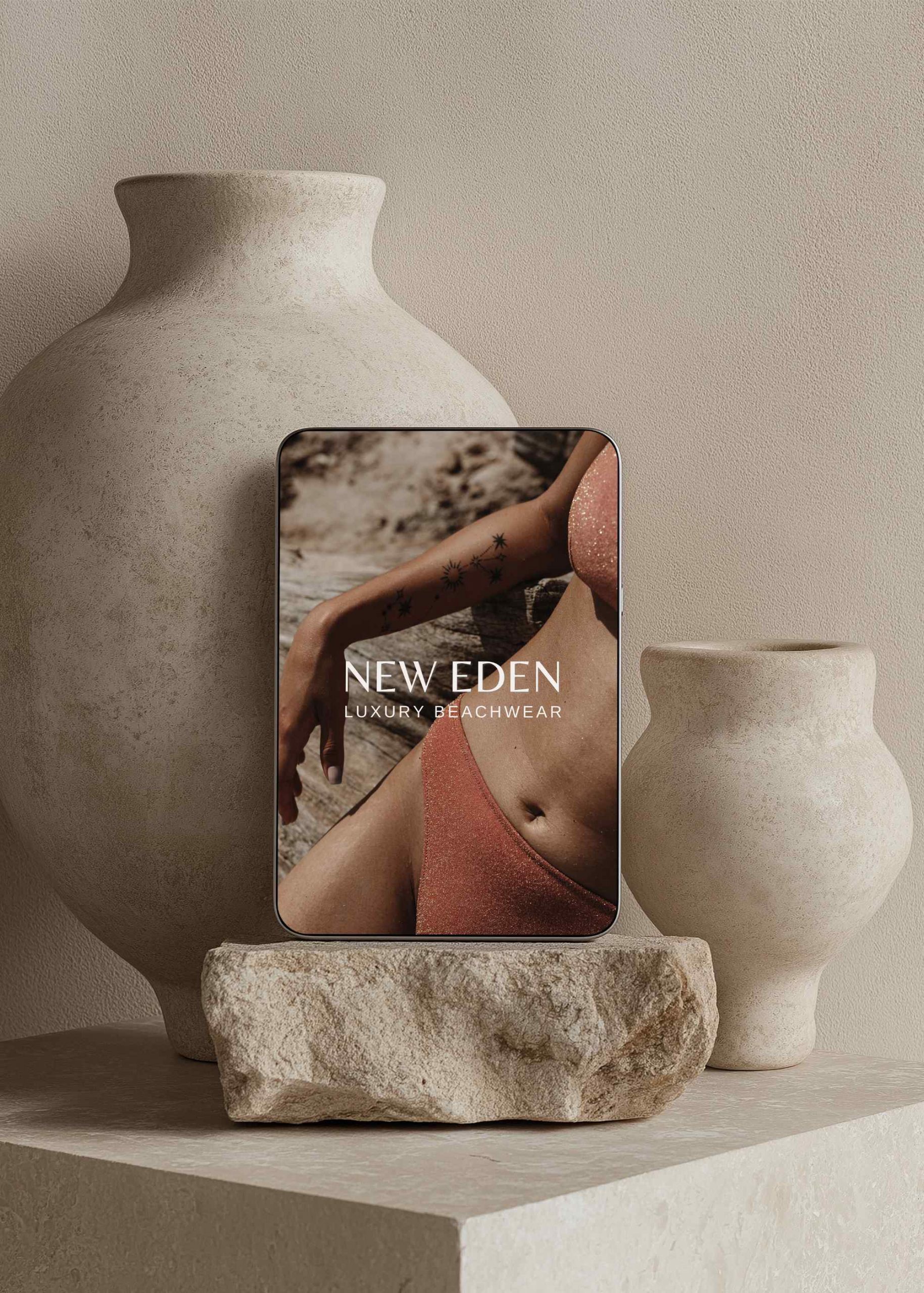 Steinsockel und Tonvasen, davor steht ein Tablet mit einem Brand Design eine Luxus Swimwear Brand von Calico Sky Studio.
