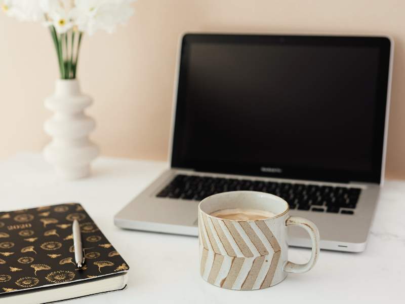 Laptop und Kaffeetasse im Boho-Stil. Website aktuell halten Anleitung