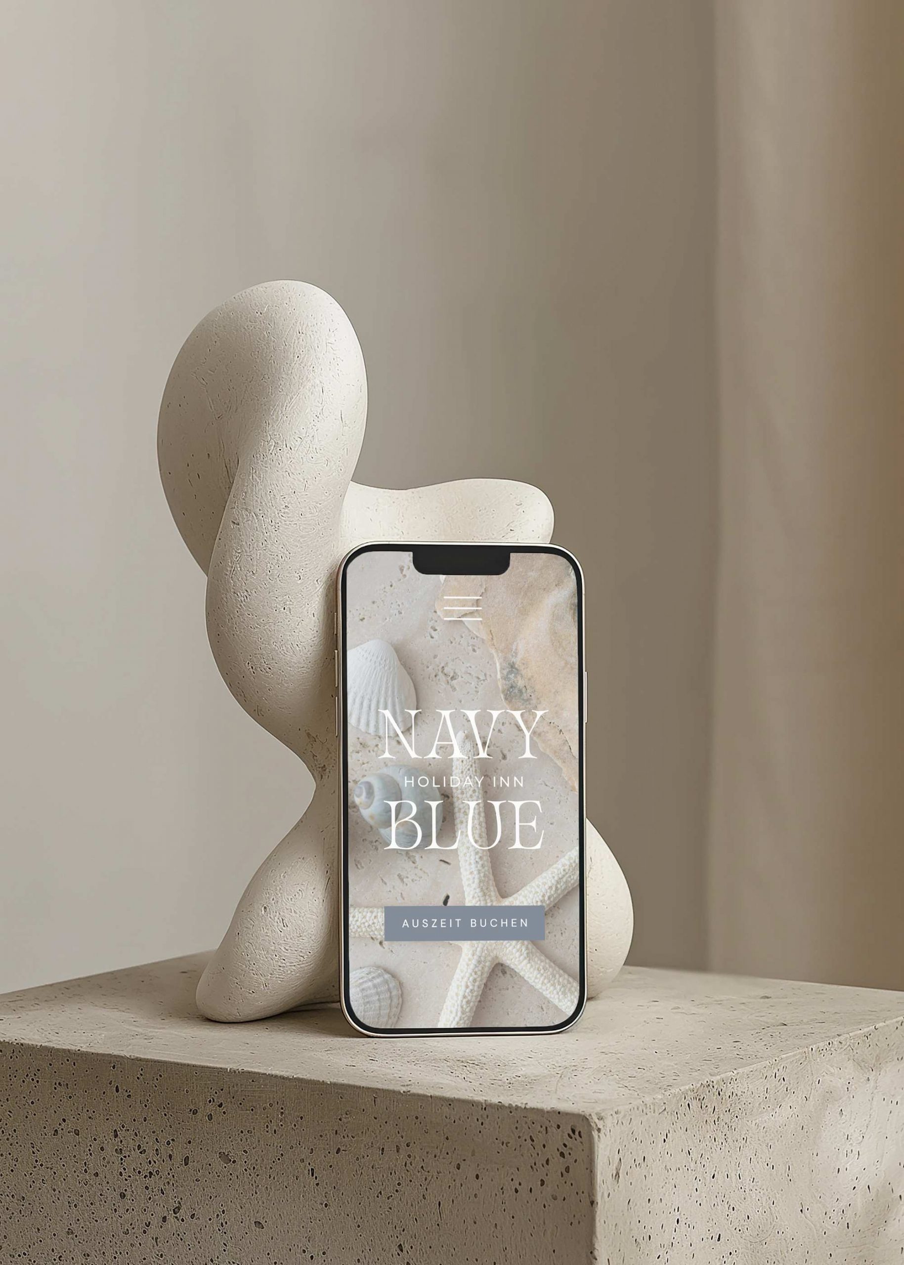 Abstrakte Skulptur auf Steinsockel, davor steht ein Smartphone mit einer Website für ein Holiday Inn - Premium Webdesign von Calico Sky Studio.