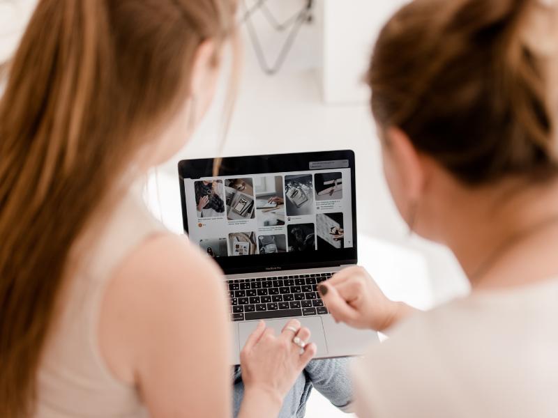 7 simple Tipps: Website Ladezeiten verbessern 1 Zwei Online Business Women vor einem Laptop mit Fotos. Bilder komprimieren um Website Ladezeit verbessern