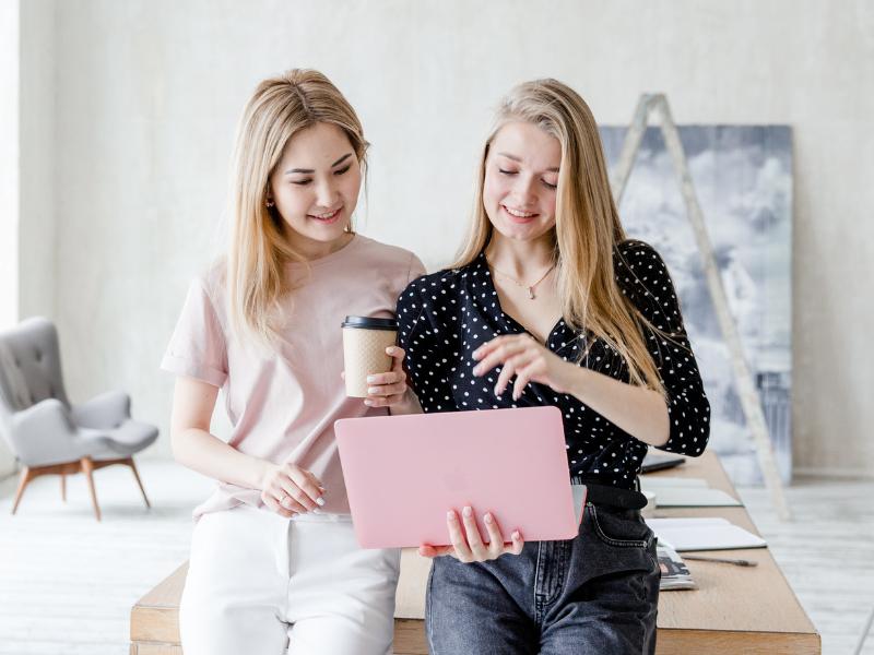 7 simple Tipps: Website Ladezeiten verbessern 2 Zwei Selbstständige Frauen mit Laptop im Co Working Space. Website Ladezeiten optimieren.